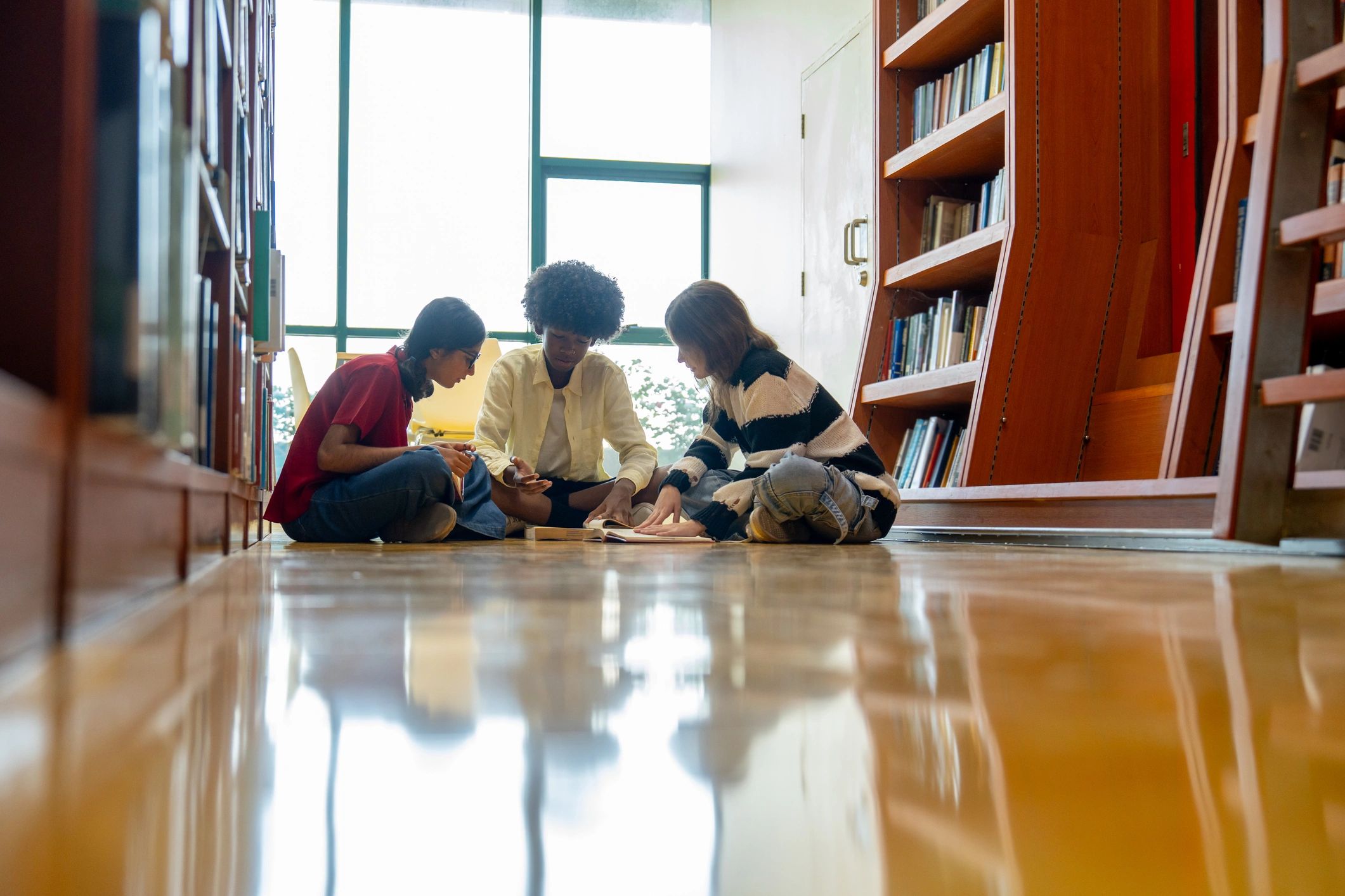 Students reading and discussing together in a library